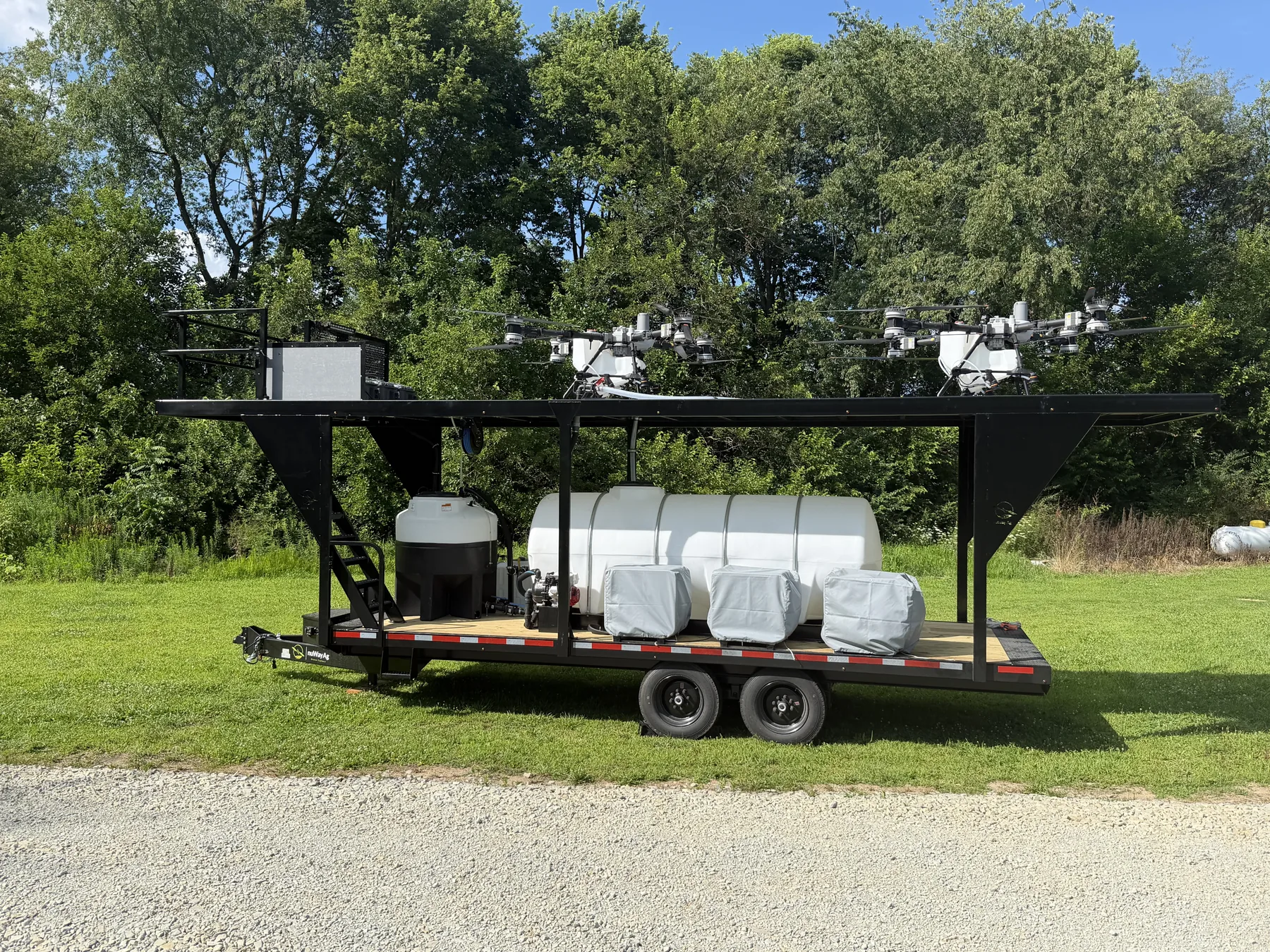 Heavenly Acres NuWay Ag application trailer staged with two DJI Agras T100 drones